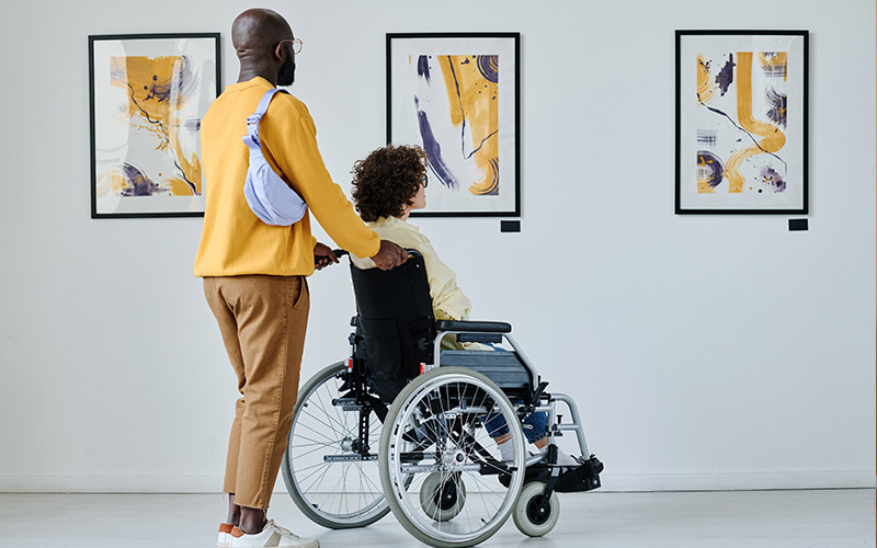 Woman in wheelchair looking at art display