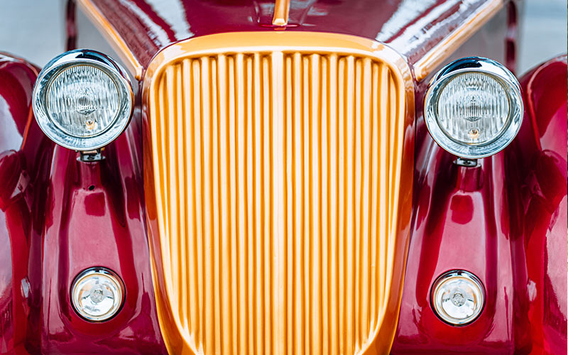 Front of a red vintage car up close